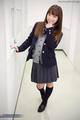 Standin in school corridor wearing pleated skirt