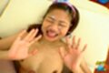 On her back eyes closed hands raised cum on her face