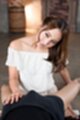 On her knees wearing white dress off the shoulder