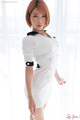 Standing beside window in white dress short hair