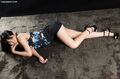 Lying on her front wearing short skirt in high heels