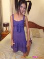 Bun kneeling on bed wearing purple dress