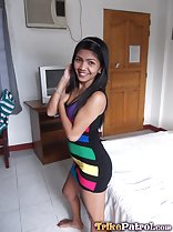 Rosalie bare foot in room standing beside bed long hair down to her colourful dress